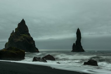 Tamamen siyah kum ve sudan yapışmasını kayalar ile bir plaj. Beach Vic. İzlanda. 