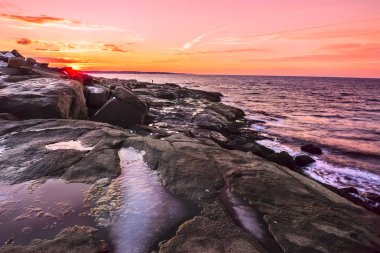 Kayalık plaj gün batımında Atlantik Okyanusu. Amerika Birleşik Devletleri. Maine.
