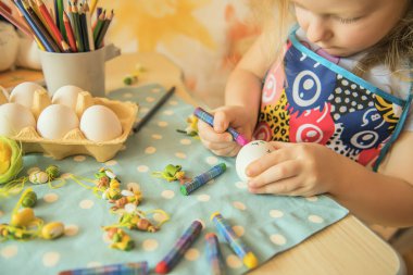 Tatlı bir küçük sarışın kız Paskalya yumurtaları boyar. Paskalya tatili için hazırlanıyor.