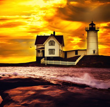 Deniz feneri ve tepedeki fenerin bekçisinin evi gün batımına karşı. Atlantik Okyanusu kıyıları ve adadaki deniz fenerinin dramatik fantastik fotoğrafı. Atlantik Okyanusu. Usa. Maine. Nubble York 