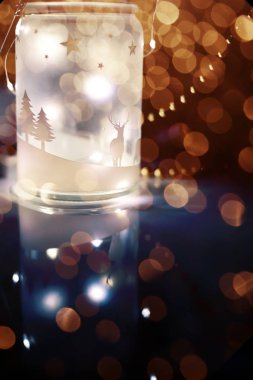 Işıklı parlak bir fener ve siyah arka planda çelenklerin renkli bokeh 'i. Noel süslemeleri ve ruh hali. Işık saçan koyu renkli bir fotoğraf..