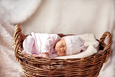 Yeni doğmuş bebek tatlı tatlı uyuyor Eski bir sepetin içinde.