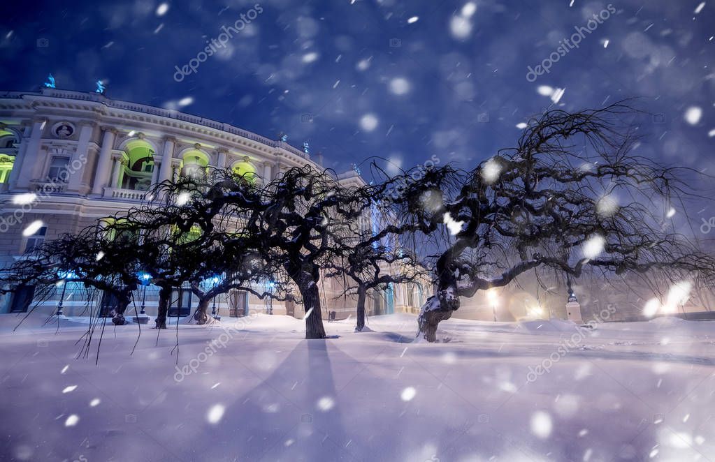 Foto nocturna de calles de la ciudad durante las nevadas. Teatro de