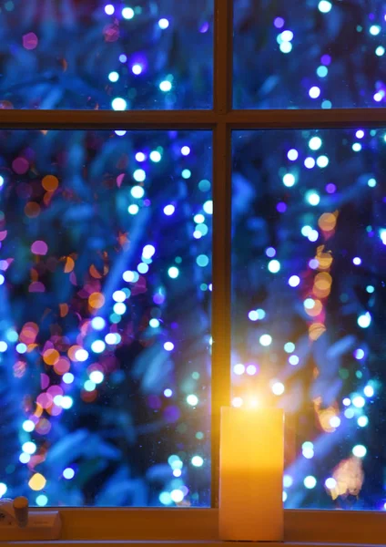 Foto Oscura Una Vela Encendida Una Ventana Con Luces Centelleantes —  Fotos de Stock