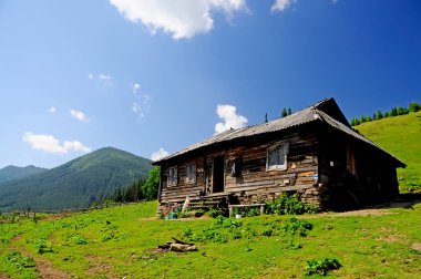 Mosnost Dağı 'ndaki basit bir çiftlik. Eski renkli ahşap çiftlik evi dağlarda peynir üretiyor. Ukrayna Karpatları.
