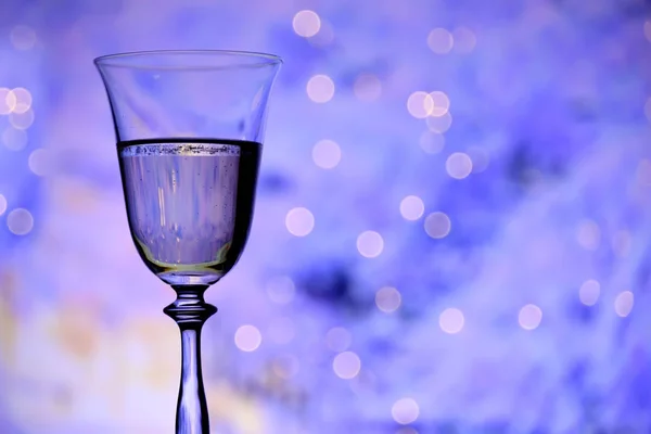 Szklanka Szampanem Musującym Winem Świątecznym Niebieskim Tle Światłami Bokeh Atmosfera — Zdjęcie stockowe