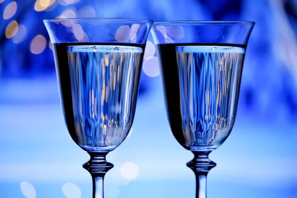Şampanyalı Iki Bardak Köpüklü Şarap Şenlikli Mavi Arka Planda Işıklar — Stok fotoğraf