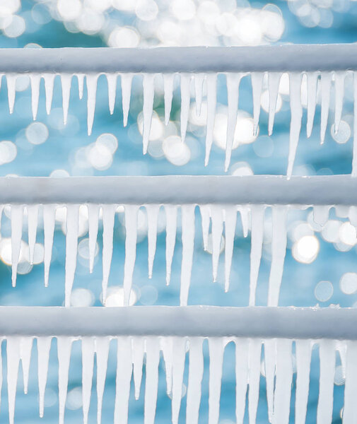 Сосульки сверкают при солнечном свете на железных перилах на берегу моря. морозный солнечный день. Зимние детали. Оттепель ждет весны
.