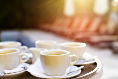 Caddedeki bir masanın üzerindeki odak kahve fincanlarından bulanık görüntü..