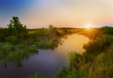 Yaz mevsiminde nehir kenarında şafak vakti. Sabah tazeliğinin güzel manzarası.