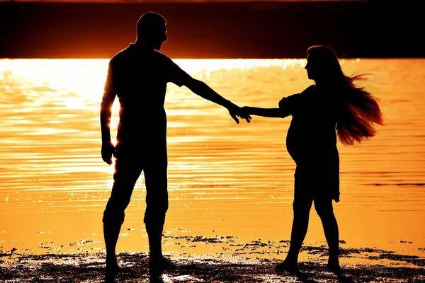 Sylwetki Faceta Ciężarnej Dziewczyny Świetle Zachodu Słońca Nad Jeziorem — Zdjęcie stockowe