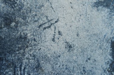 Kırık boyalı arka planı olan gri-mavi çatlamış beton..