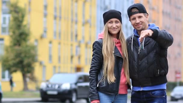Joven pareja feliz sosteniendo las llaves de su nuevo hogar — Vídeos de Stock
