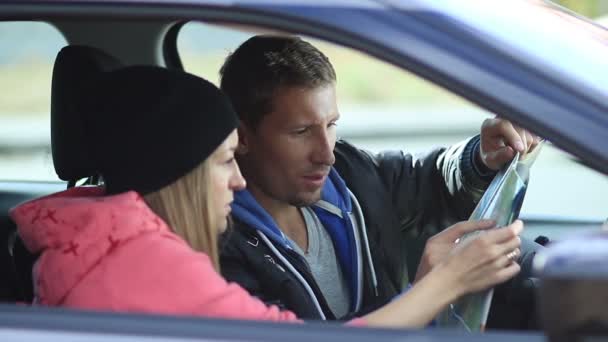 Bonito casal no carro procurando a direção certa — Vídeo de Stock