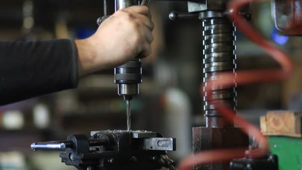 Man drilling in steel plate with bench drill — Stock Video