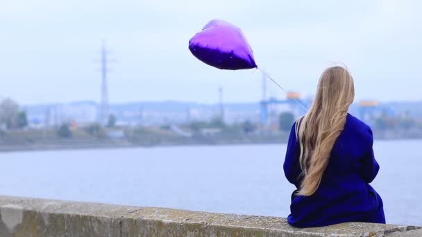 Sad girl with broken heart holding heart balloon — Stock Video