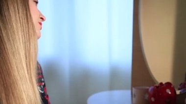 Kadın yatak odasında uzun parlak saçları fırçalama