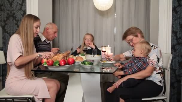 Счастливая семья ест традиционную еду на День Благодарения — стоковое видео