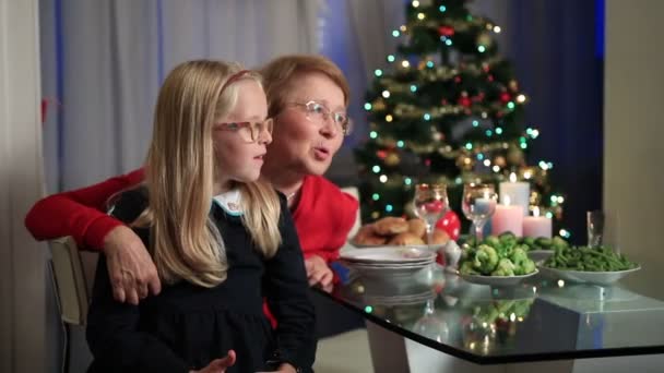 Niña sentada en abuelitas regazo en Navidad — Vídeo de stock