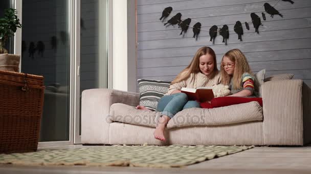 Jovem mãe lendo um livro para sua filha bonito — Vídeo de Stock