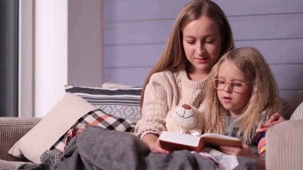 Μητέρα και κόρη ανάγνωση ιστορία βραδινό ύπνο στον καναπέ — Αρχείο Βίντεο