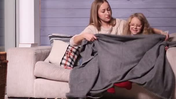 Madre e hijo calentándose bajo una manta en casa — Vídeo de stock