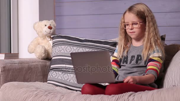 微笑的小女孩，有手提电脑在家里 — 图库视频影像