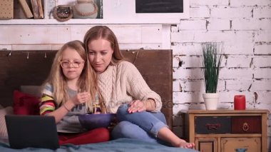 Anne ve kızı laptop çizgi film izlerken