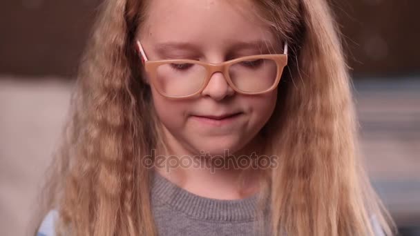 Schattig klein meisje in glazen glimlachen — Stockvideo