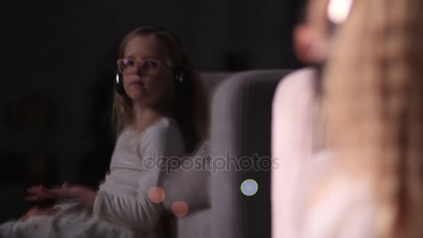 Petite fille mignonne dans les écouteurs jouissant de la musique — Video