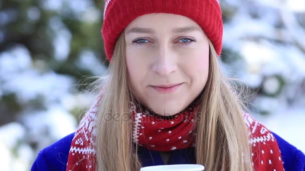 Молодая женщина наслаждается ароматом кофе зимой — стоковое видео