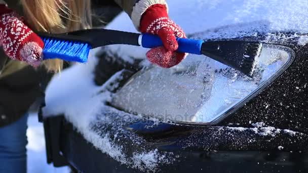 驱动程序在冬天刮冰从车头灯 — 图库视频影像