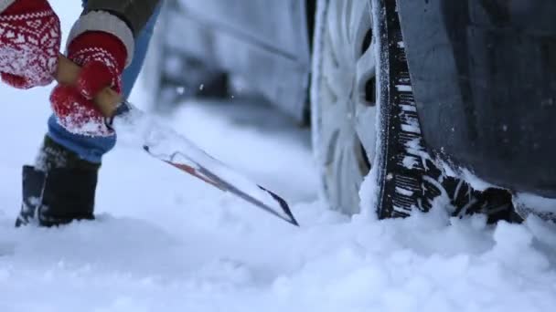 Close up of woman shoveling snow from car — Stock Video