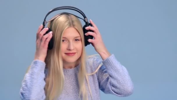 Charmantes Mädchen mit Kopfhörern, das Musik hört — Stockvideo