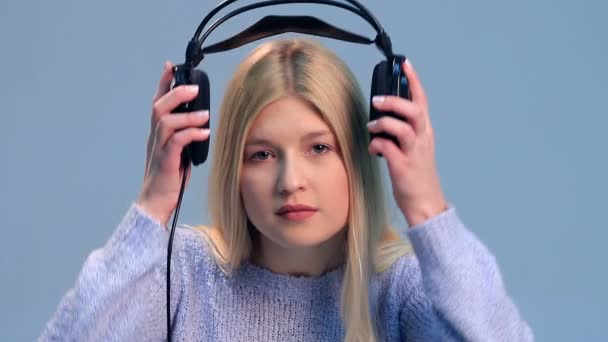 Красивая девушка слушает музыку в наушниках — стоковое видео