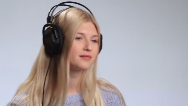 Hermosa mujer escuchando música en auriculares — Vídeo de stock