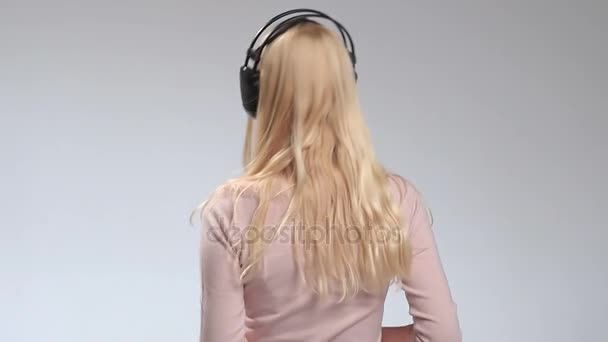 Feliz chica sonriente escuchando música en auriculares — Vídeos de Stock