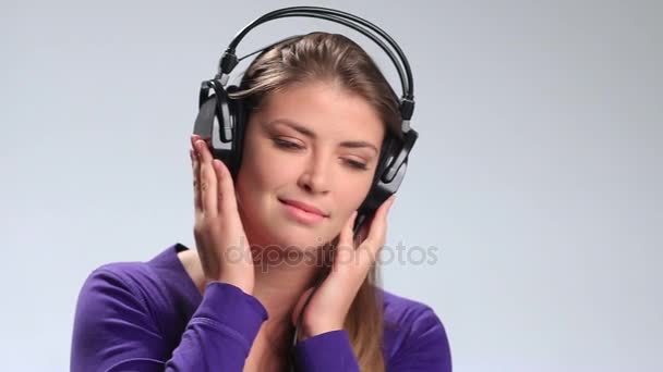 Preciosa joven escuchando música en auriculares — Vídeos de Stock