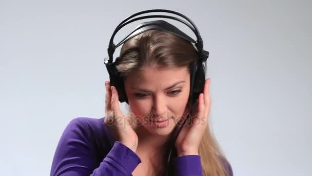 Сексуальная молодая женщина слушает музыку игриво — стоковое видео