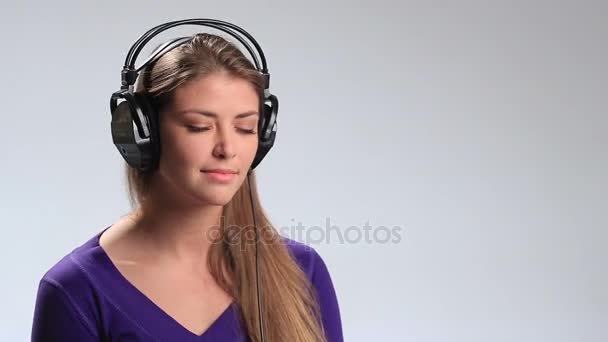 Muchacha atractiva escuchando música auriculares — Vídeo de stock