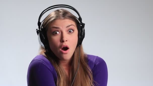 Energiegeladenes junges Mädchen hört Musik über Kopfhörer — Stockvideo