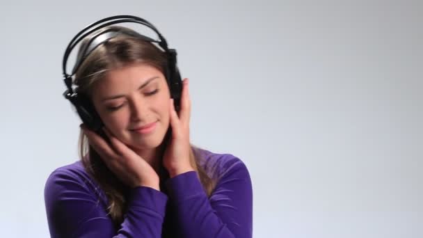 Mujer sensual escuchando música en auriculares — Vídeos de Stock