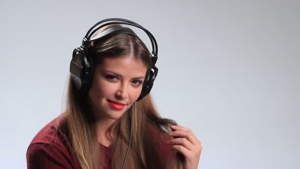 Provokativní mladá brunetka pózuje se sluchátky — Stock video