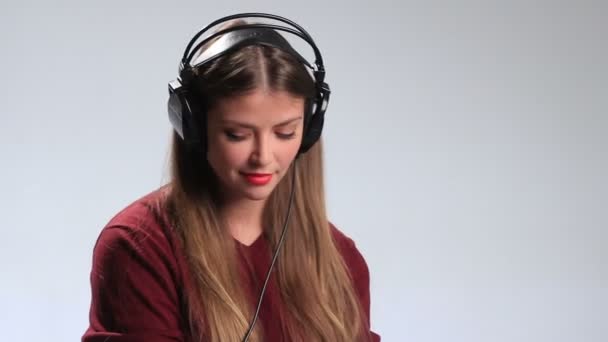 Jovencita juguetona disfrutando de la música en auriculares — Vídeo de stock