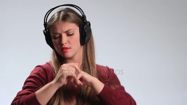 Экспрессивная женщина слушает музыку в наушниках — стоковое видео