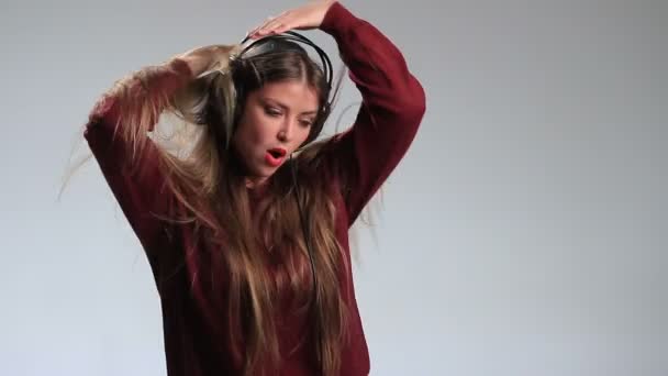 Емоційна красива жінка з навушниками танцює — стокове відео