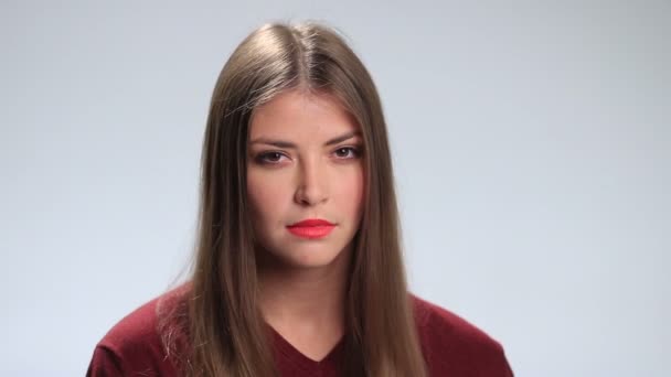 Молодая женщина с грустным выражением над белым — стоковое видео