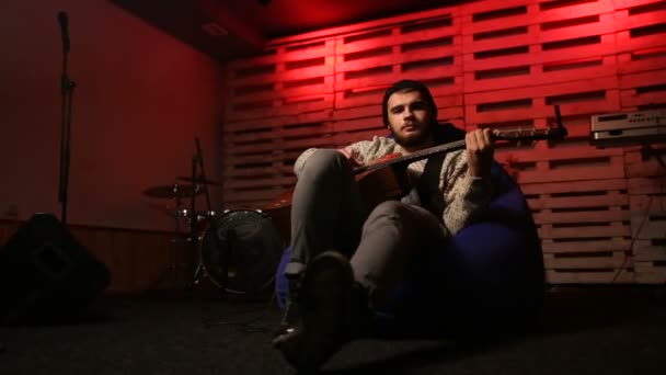 Стильный гитарист, собирающий аккорды на акустической гитаре — стоковое видео
