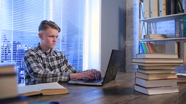 Gelukkig student werkt aan laptop in bibliotheek — Stockvideo