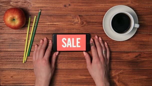 Смартфон на женской руке с продажей на экране — стоковое видео